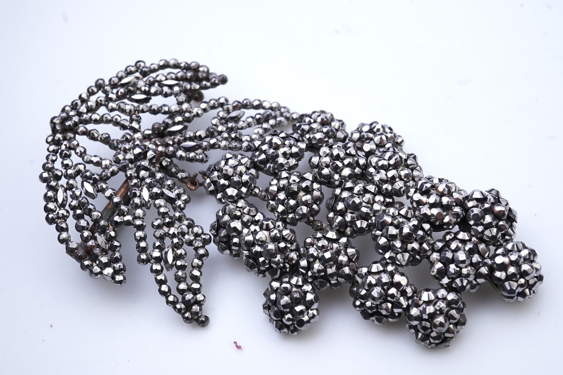 A cut steel brooch, 19th century, and a pink paste pendant